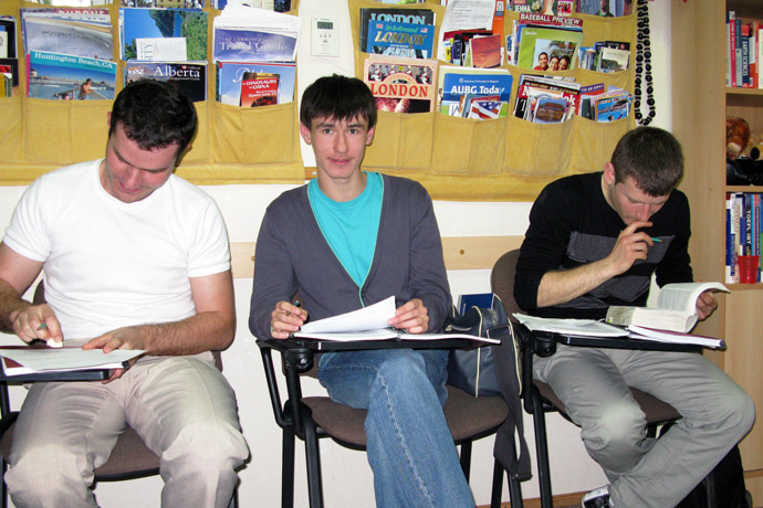 Filling out course evaluation forms at Terra Nova. From left to right: Andrei Bușmachiu, Gleb Miron, Sergiu Opinca. TOEFL Preparation / Section 5 (Sat.Sun. Morning Group). May 2012.